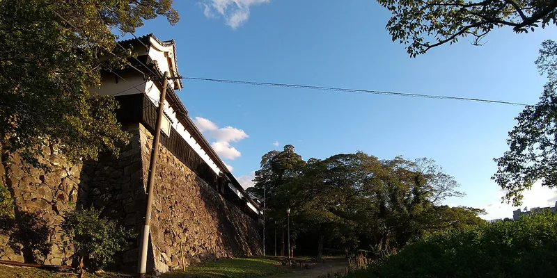 Stone walls and the Tamon-yagura turret of Fukuoka Castle beneath green trees