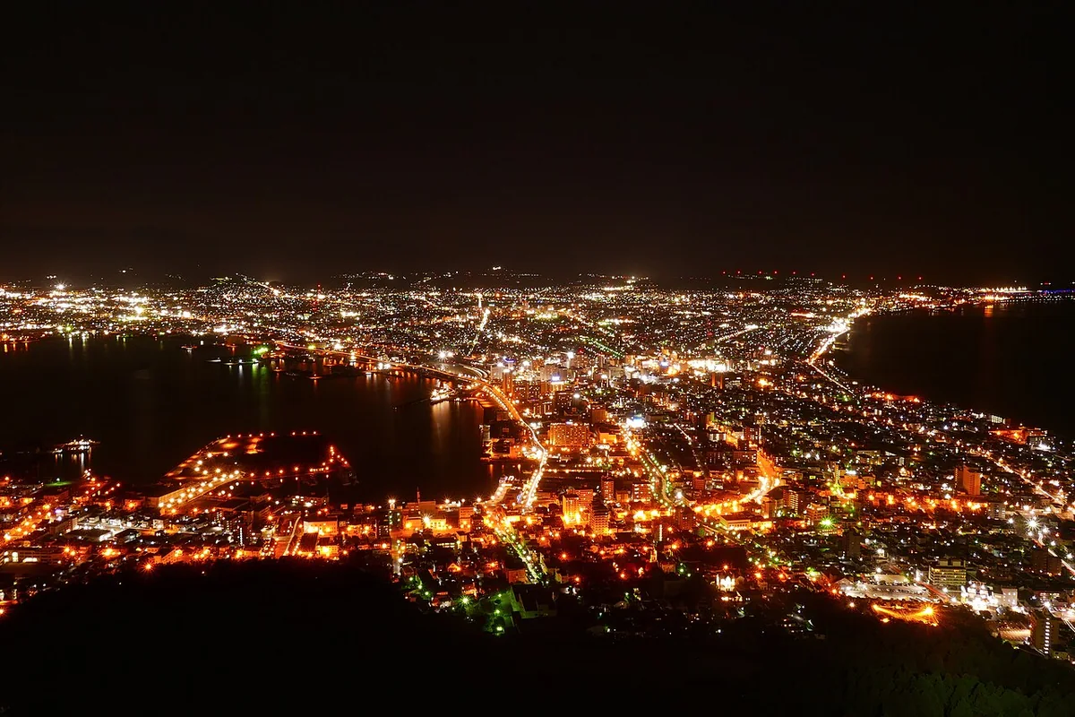 Hakodate’s glittering city lights and curving coastline seen from Mount Hakodate at night
