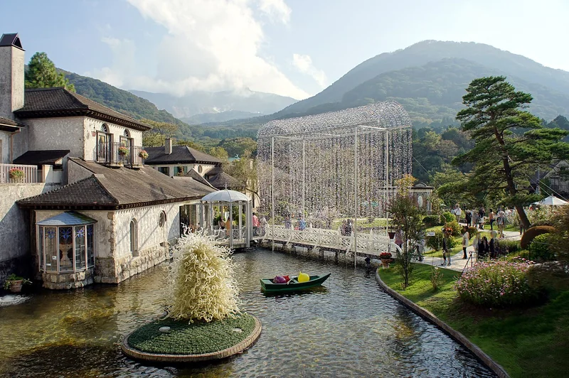 Stone museum buildings and a pond in the garden at Hakone Venetian Glass Museum