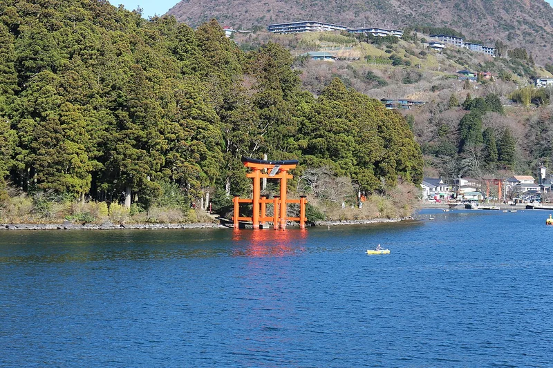 The red lakeside torii of Hakone Shrine against wooded hills beside Lake Ashi
