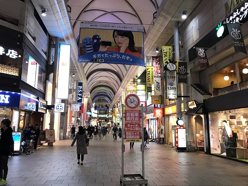 People walking beneath the covered arcade of Hiroshima Hondori shopping street