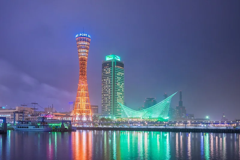 Kobe Port Tower and the Maritime Museum reflected in the water, seen from Harborland at twilight