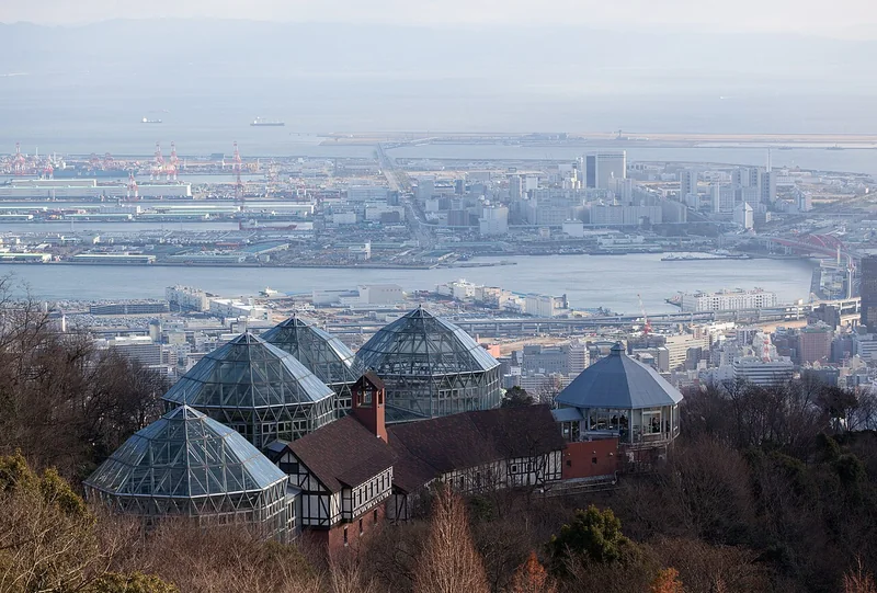 Glasshouses at Nunobiki Herb Gardens with Kobe and its harbour beyond