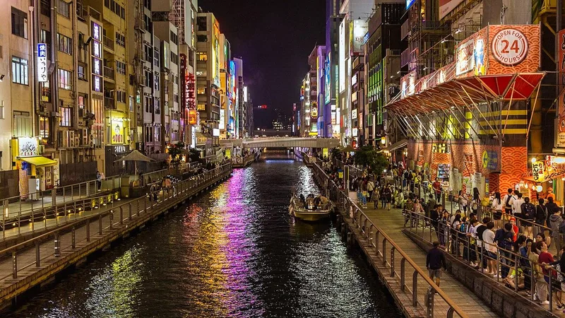 Bright restaurant signs reflected in the Dotonbori canal at night