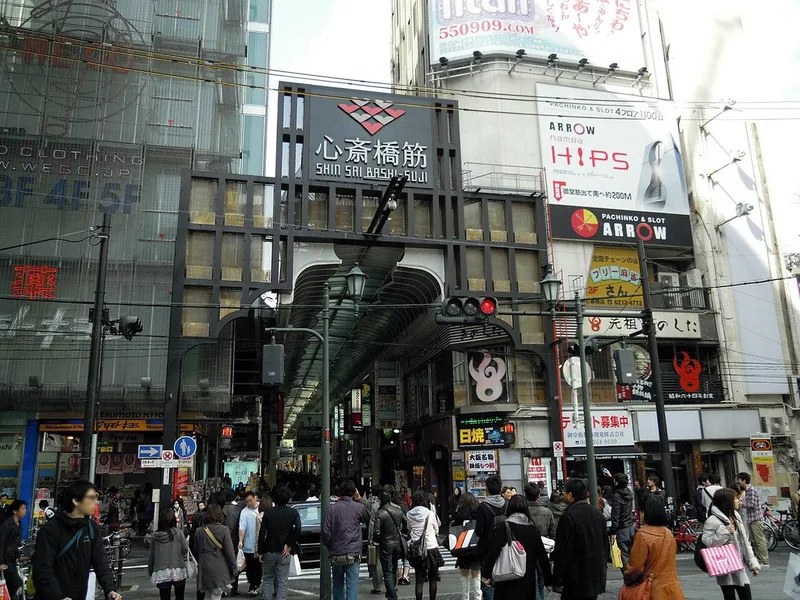 Shoppers beneath the entrance to the Shinsaibashi-suji shopping arcade