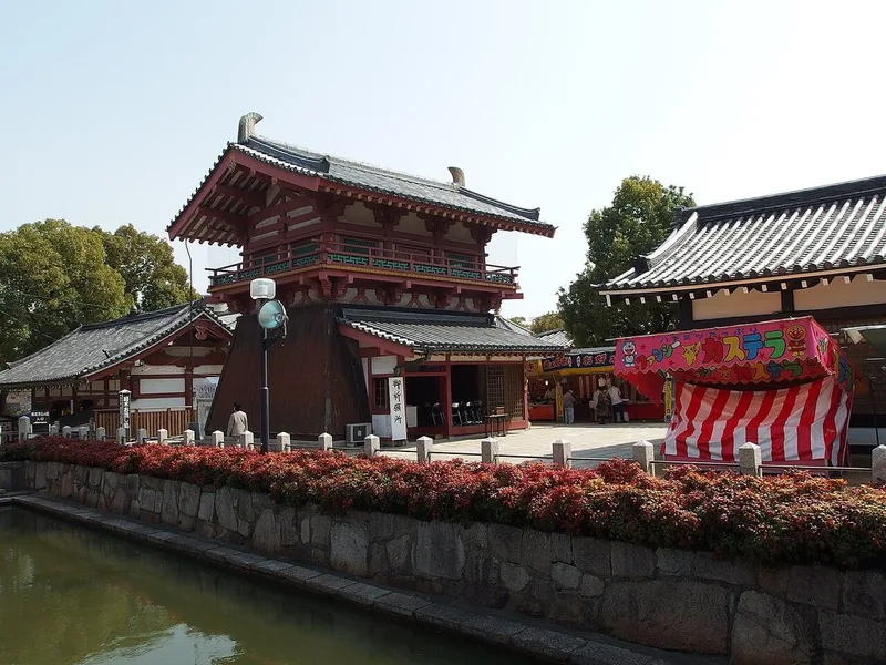 Traditional temple buildings beside a pond in the Shitennoji grounds