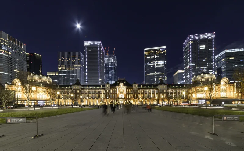 Tokyo Station's illuminated red-brick Marunouchi building across its broad plaza at night