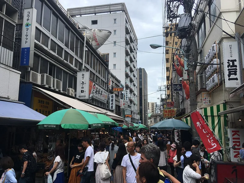 Shoppers walking between food stalls in Tsukiji Outer Market