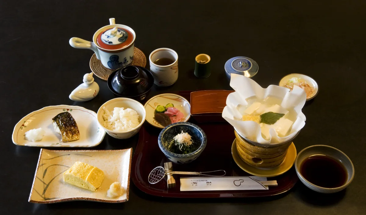 A Kyoto breakfast set with rice, grilled mackerel, omelette, tofu and small accompaniments.