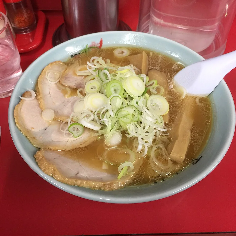 Ramen with broth, sliced pork, bamboo shoots and spring onion.