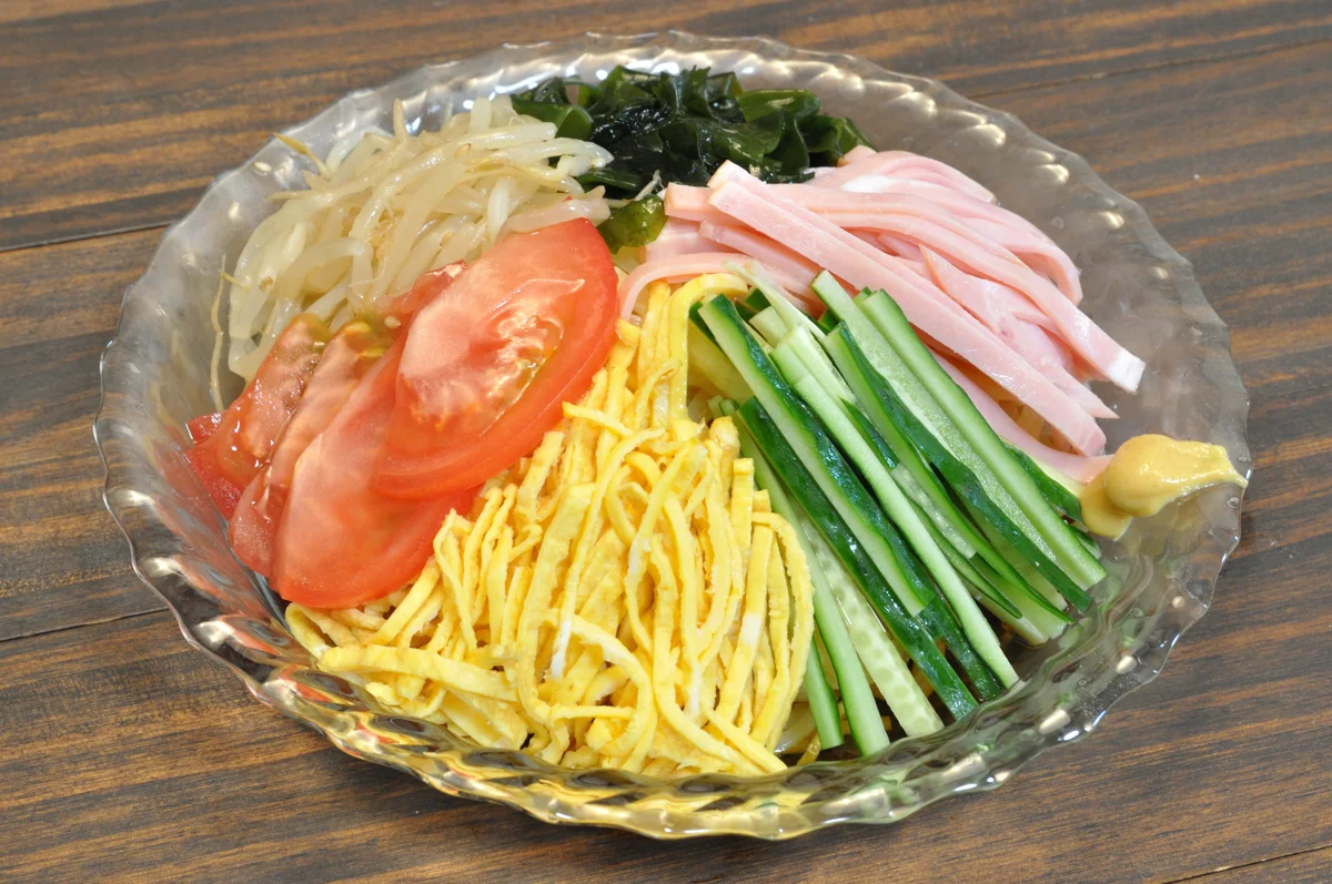 Chilled noodles with tomato, cucumber, ham and shredded egg.