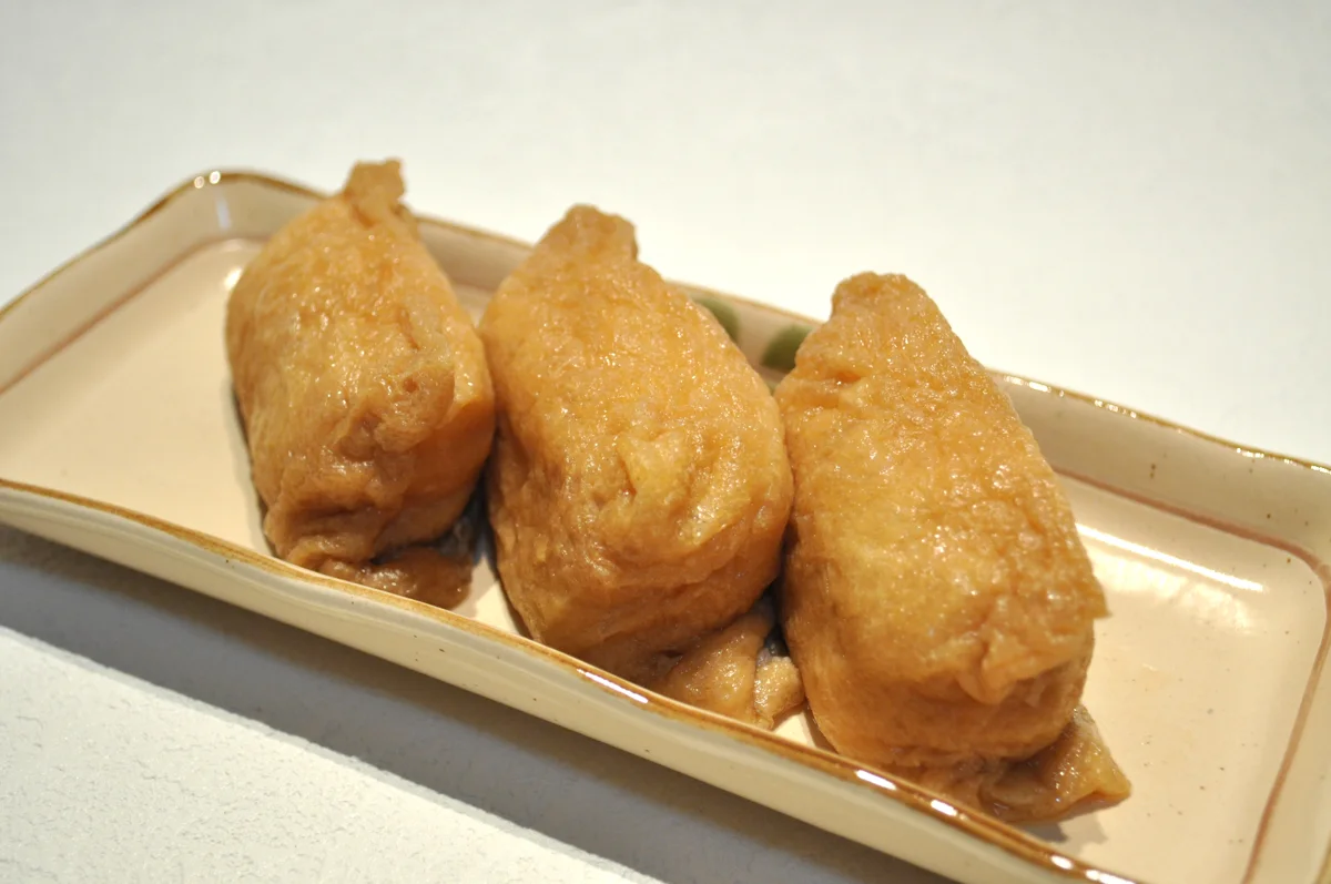 Sushi rice inside seasoned tofu pouches.