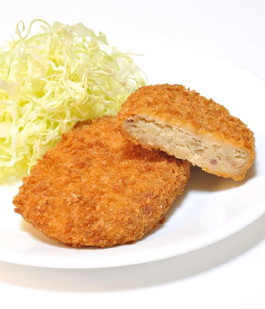 Potato croquettes, with one cut open to show its filling.