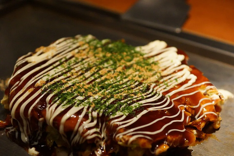 Okonomiyaki with sauce and a mayonnaise-style topping.
