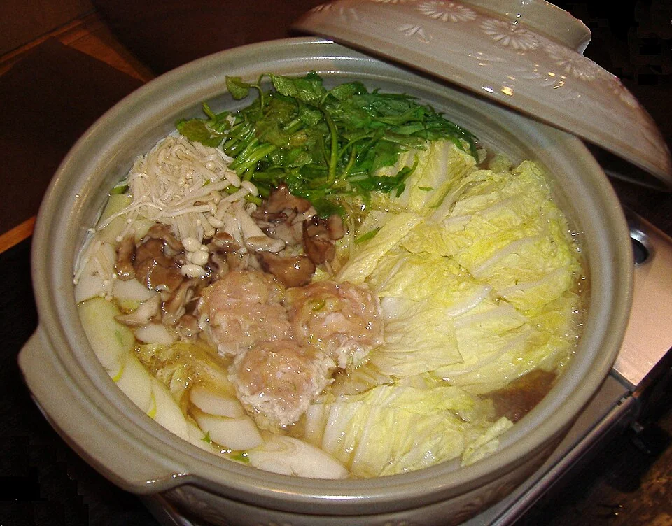 A hotpot with cabbage, tofu and other ingredients.