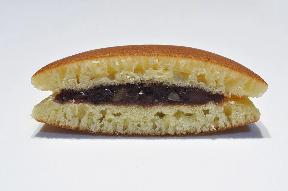 A cut dorayaki showing bean paste and chestnut in the filling.