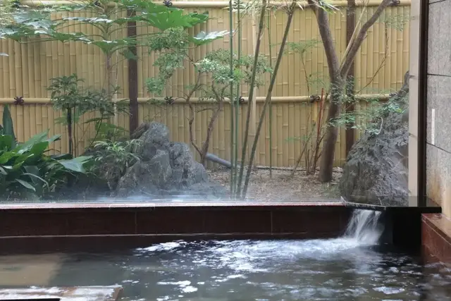 The garden-facing natural hot-spring bath at Hotel Monarque Tottori