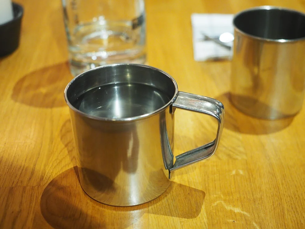 A metal drinking cup used as a shape reference. Japanese tin sake cups differ