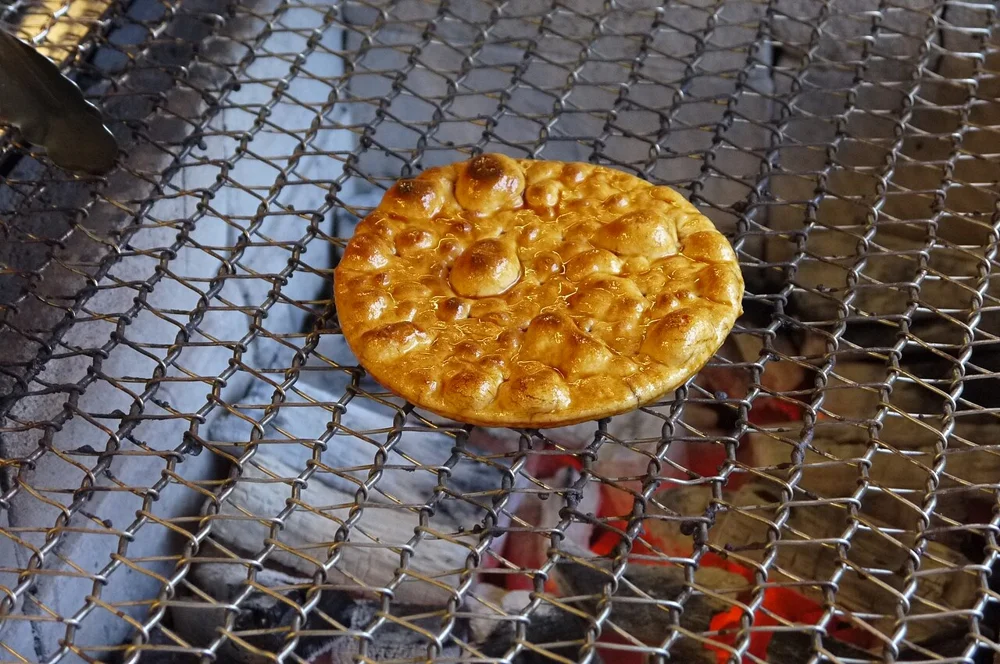 A senbei rice cracker being toasted
