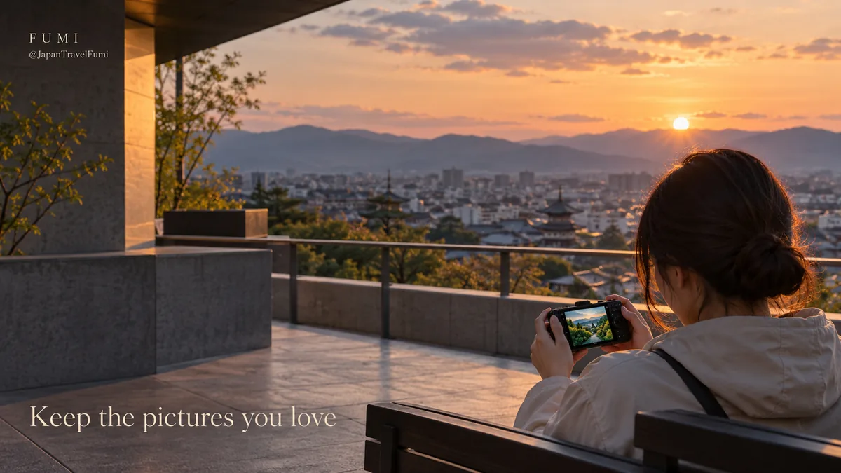A traveller reviews a favourite landscape photograph on a camera while seated above the city at sunset.